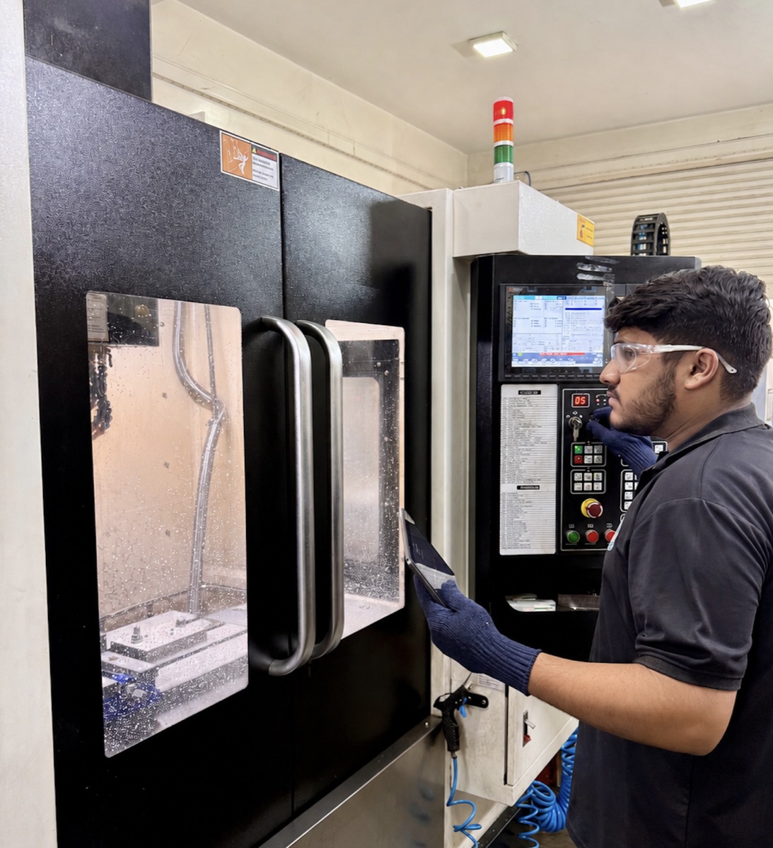 A machinist running a CNC machining centre at Shivayu Aerospace